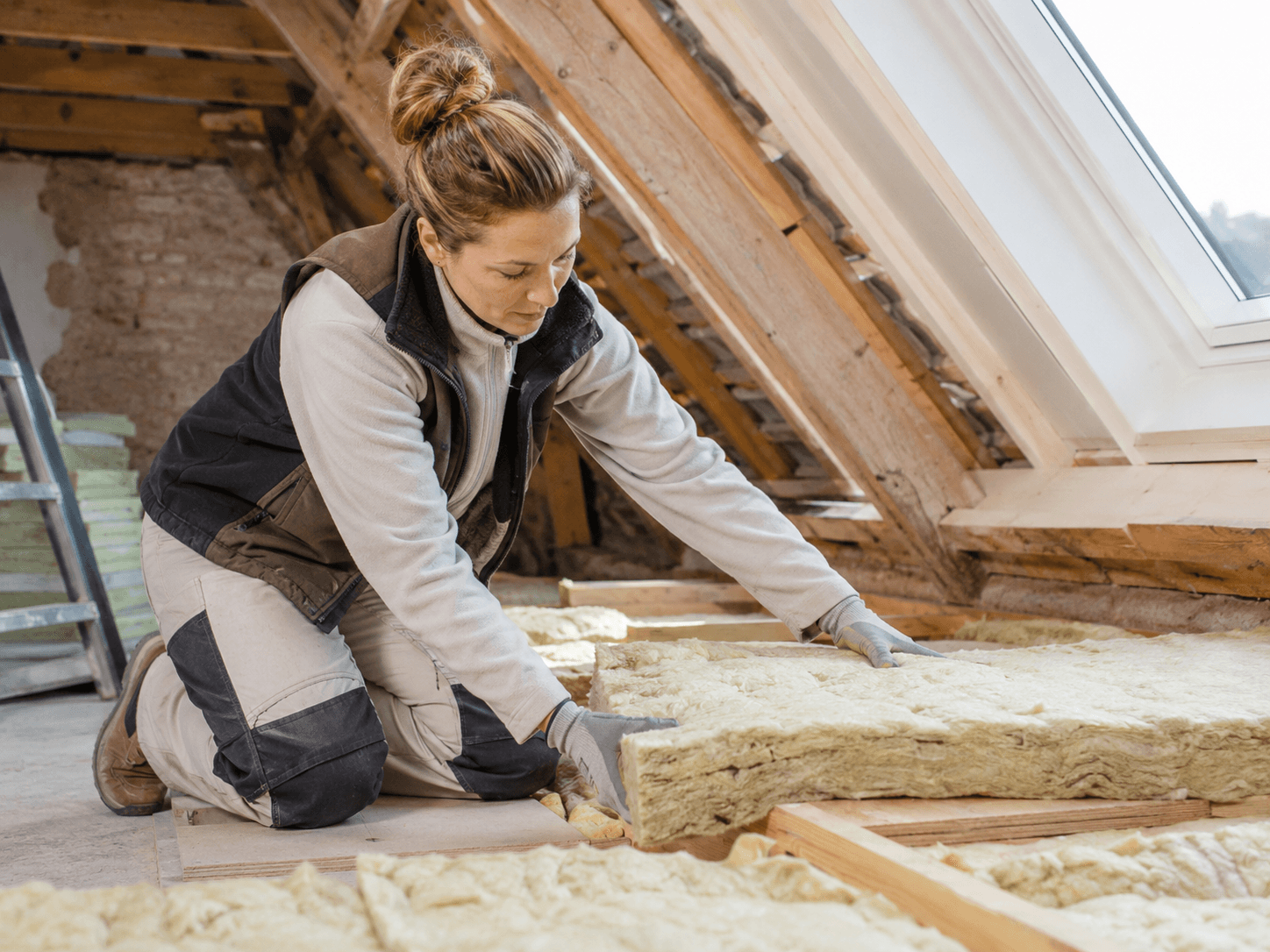 Technicienne posant de l'isolation dans les combles